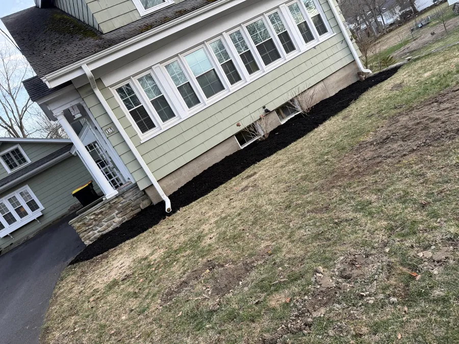 Fresh black mulch bed installed along home foundation by TB Lawn and Landscape